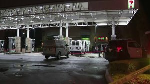 Officers are seen outside a 7-11 store in Santa Ana where a man was fatally shot by police on March 2, 2018. (Credit: KTLA)