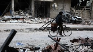 A person rides a bicycle through an area of destroyed homes local residents were searching through for their belongings in the Al-Asqalani neighborhood in Irbin town, Eastern Ghouta in Syria on Feb. 28, 2018. The neighborhood was bombed on Feb. 22, 2018, when civilians were left seeking refuge in basements. (Credit: Syrian American Medical Society via CNN)