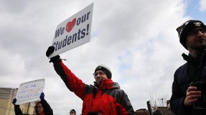 West Virginia teachers, students and supporters hold signs on a Morgantown street as they continue their strike on March 2, 2018, in Morgantown, West Virginia. (Credit: Spencer Platt/Getty Images)