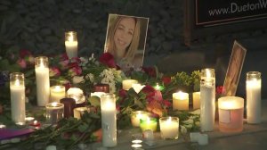 Candles, flowers and a photo of 25-year-old Adea Shabani sit outside the actress's apartment building as a memorial following the news that remains found in Northern California are believed by LAPD to be hers on March 27, 2018. (Credit: KTLA)