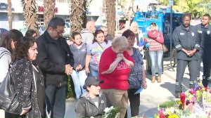 Mourners attend a vigil held in honor of Pomona Police Officer Gregg Casillas, who was killed, and a wounded officer who is recovering in the hospital. (Credit: KTLA)