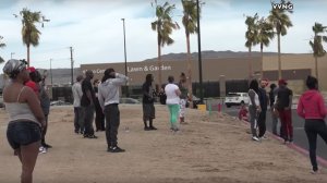 Several onlookers stand in a Walmart parking lot after a man was killed and a woman wounded by Barstow police on Apri 5, 2018. (Credit: Victor Valley News Group)