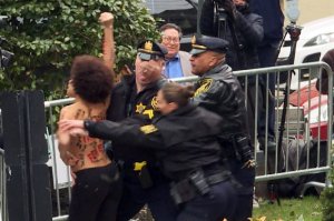 In these video framegrabs from AFP TV, sheriff's officers detain a protester interrupting the arrival of Bill Cosby for the first day of his second trial for sexual assault case at the Montgomery County Courthouse in Norristown, Pennsylvania on April 9, 2018. (Credit: Diane Desobeau/AFP/Getty Images)