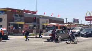 A pedestrian is struck in a South L.A. intersection on April 11, 2018 where a vigil was being held for a bicyclist who was fatally struck in a hit-and-run crash the day before. (Credit: KTLA)