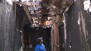 An man examines damage at the scene of a fire that left two dead in Studio City on April 14, 2018. (Credit: KTLA)