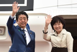 Japan's Prime Minister Shinzo Abe and his wife Akie wave as they depart for the U.S. from Tokyo's Haneda airport on April 17, 2018. (Credit Kazuhiro Nogi/AFP/Getty Images)