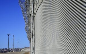 Barbed wire fencing runs across the top of the steel structure in the Border Infrastructure System  in San Diego on April 17, 2018. (Credit:  FREDERIC J. BROWN/AFP/Getty Images)