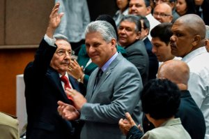 Cuban President Raul Castro (left) waves next to First Vice-President Miguel Diaz-Canel (center) during a National Assembly session that will select Cuba's Council of State ahead of the naming of a new president, in Havana on April 18, 2018. (Credit: STR/AFP/Getty Images)