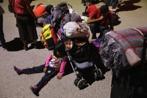 Central American asylum seekers wait for buses to take them to their next destination on their "caravan" north to the U.S.-Mexico border on April 23, 2018, in Hermosillo, Mexico. (Credit: John Moore / Getty Images)