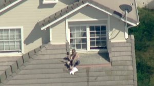 A man sits on top of a home in Hacienda Heights during a standoff with law enforcement on April 24, 2018. (Credit: KTLA)