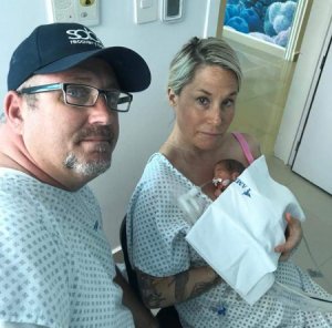 Jeremy and Maggie Stewart sit with their new daughter Poppy after she was born at 6 months following an emergency C-section in Mexico. (Credit: Jeremy Stewart)
