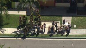 Children are seen being wheeled out in cribs as crews evacuate the preschool Academy on the Hills after a fatal gas leak explosion at a nearby office building. (Credit: KTLA)