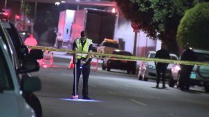 An investigator looks through the scene in South L.A. where a 3-year-old child was struck by a vehicle on May 20, 2018. (Credit: KTLA)