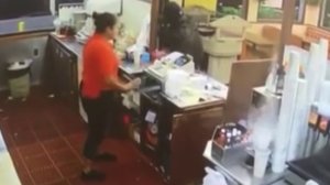 A surveillance image shows an alleged robber and an employee inside a Santa Ana restaurant on May 26, 2018. (Credit: Cozy Corner Drive-In)