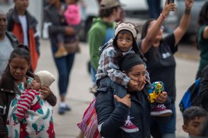 Women and children who are part of a caravan of Central Americans traveling across Mexico walk from Mexico to the U.S. side of the border to ask authorities for asylum on April 29, 2018 in Tijuana. (Credit: David McNew/Getty Images)