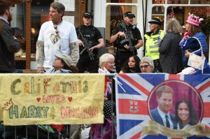 Armed police stand guard as Royal well-wishers prepare to bed down for the night on the High Street outside Windor Castle in Windsor on May 18, 2018, the eve of Britain's Prince Harry's royal wedding to actress Meghan Markle. (Credit: Oli Scarff / AFP / Getty Images)