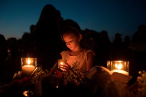 Lucretia Martinez, 7, stands before various momentos people have left during a candlelight vigil in Santa Fe, Texas, for the victims of the mass shooting on May 18, 2018. (Credit: AFP / Getty Images)