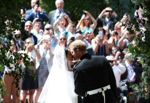 Britain's Prince Harry, Duke of Sussex kisses his wife Meghan, Duchess of Sussex as they leave from the West Door of St George's Chapel, Windsor Castle, in Windsor, on May 19, 2018 after their wedding ceremony. (Credit: DANNY LAWSON/AFP/Getty Images)