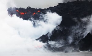 Steam rises as lava enters the Pacific Ocean at dawn, after flowing to the water from a Kilauea volcano fissure, on Hawaii's Big Island on May 22, 2018. (Credit: Mario Tama / Getty Images)