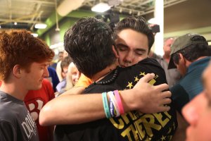 David Hogg hugs Manuel Oliver, whose son Joaquin Oliver, was killed in the Marjory Stoneman Douglas High School mass shooting as they particpate in a "die'-in" protest in a Publix supermarket on May 25, 2018, in Coral Springs, Florida. (Credit: Joe Raedle/Getty Images)