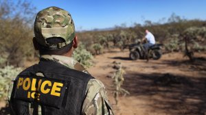 U.S. Immigration and Customs Enforcement tactical officer Kevin Carlos watches as a fellow officer drives off an ATV on Jan. 18, 2011, in the Tohono O'odham Nation, Ariz. (Credit: John Moore/Getty Images)