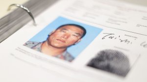 A binder containing the Los Angeles Police Department's files on Koreatown triple-murder suspect, Tai Zhi Cui, shows an image of him alongside his signature. (Credit: Myung J. Chun / Los Angeles Times)