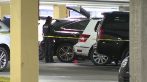 Investigators search for evidence in a Mercedes-Benz GLK parked in a Rolling Hills Estates mall garage after a woman was found stabbed to death inside the SUV on May 3, 2018. (Credit: KTLA)