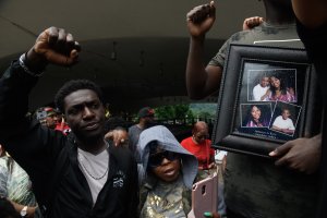 A man holds a photo of Antwon Rose as he joins a protest for the police shooting of Rose during a Juneteenth celebration on June 23, 2018 in Pittsburgh, Pennsylvania. (Credit: Justin Merriman/Getty Images)