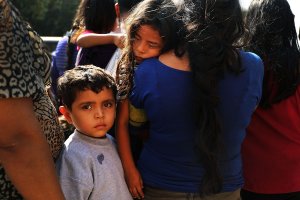 Dozens of women, men and their children, many fleeing poverty and violence in Honduras, Guatamala and El Salvador, arrive at a bus station following release from Customs and Border Protection on June 23, 2018, in McAllen, Texas. (Credit: Spencer Platt / Getty Images)