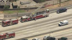 Firefighters salute the van carrying the body of slain Long Beach Fire Capt. Dave Rosa as it travels down the 710 Freeway en route to the coroner's office on June 25, 2018. (Credit: KTLA)