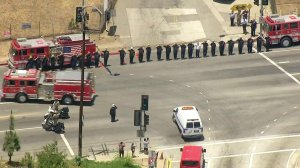 Firefighters salute the van carrying slain Long Beach Fire Department Capt. Dave Rosa as the procession travels to the coroner’s office on June 25, 2018. (Credit: KTLA)