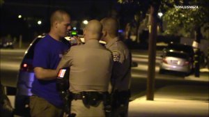 Los Angeles County Sheriff's Deputy Nicholas Smith blows into a breathalyzer before his arrest on suspicion of drunken driving on June 17, 2018. (Credit: Don Luis Meza)