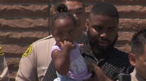Faith, a 1-year-old baby from Carson, was saved by L.A. County Sheriff's deputies on July 21, 2018. Here, she appears at a news conference days later on July 26, 2018. (Credit: KTLA)
