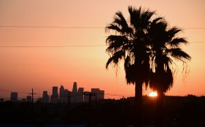The sun sets behind the downtown Los Angeles skyline on April 11, 2017. (Credit: FREDERIC J. BROWN/AFP/Getty Images)