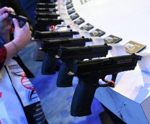 An attendee looks at handguns at the Smith & Wesson booth at the 2018 National Shooting Sports Foundation's Shooting, Hunting, Outdoor Trade Show at the Sands Expo and Convention Center on January 23, 2018, in Las Vegas. (Credit: Ethan Miller/Getty Images)