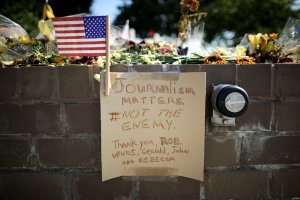 Flowers and a hand-written note adorn a makeshift memorial outside the Capitol Gazette offices in Annapolis, Maryland, on July 2, 2018, for the employees killed by a gunman the week before. (Credit: Chip Somodevilla / Getty Images)