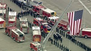 Firefighters line up for a procession for slain Long Beach Fire Department Capt. Dave Rosa on June 3, 2018. (Credit: KTLA)