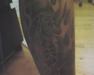 A tattoo worn by L.A. County Sheriff's Deputy Samuel Aldama is seen in a photo displayed during a press conference held by the Sweeney Firm on July 14, 2018. (Credit: KTLA)