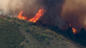 Rising into the sky, flames from the Holy Fire in the Trabuco Canyon area are swept up by winds on Aug. 6, 2018. (Credit: KTLA)