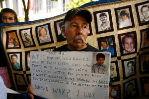 Frank Zamorro holds a placard with a picture of his son Dominic, who was allegedly abused by Father Michael Baker at age 7, during a press conference outside the Los Angeles County Courthouse where a record settlement between the Archdiocese of Los Angeles and plaintiffs who allege they were sexually abused by clergy members is to be presented for approval by a judge on July 16, 2007. (Credit: David McNew/Getty Images)