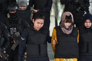 Vietnamese national Doan Thi Huong (front, second from right) and Indonesian national Siti Aisyah (back, second from left) are escorted by Malaysian police after a court session for their trial for their alleged roles in the assassination of Kim Jong Nam at the Shah Alam High Court, outside Kuala Lumpur, on June 27, 2018. (Credit: Mohd Rasfan / AFP / Getty Images)