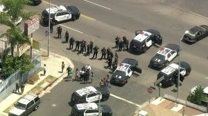 A large crowd gathered at a South L.A. intersection after a pursuit came to an end on Aug. 2, 2018. (Credit: KTLA)