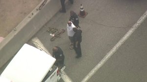 A man is detained after being found with replica firearms at LAX on Aug. 17, 2018. (Credit: KTLA)