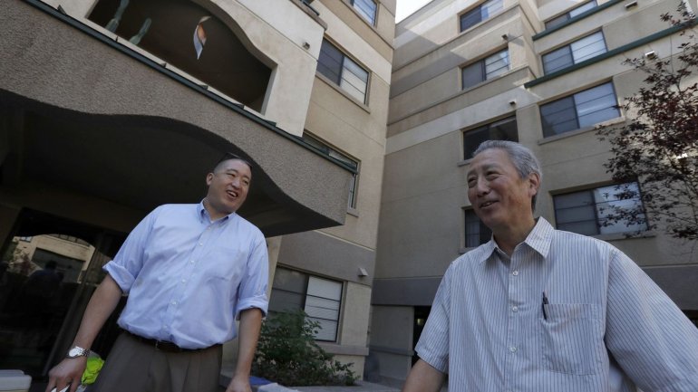 Grant Sunoo, left, and Erich Nakano, executives with the Little Tokyo Service Center, stand in the courtyard of an affordable housing project at Casa Heiwa in Little Tokyo. (Credit: Luis Sinco / Los Angeles Times)