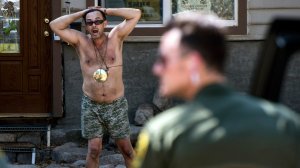 Sheriff deputies talk to Forrest Gordon Clark, a Holy Jim Canyon resident whose home was the only surviving structure in in his 14 cabin area. (Credit: Mindy Schauer / Orange County Register via Getty Images)