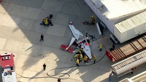 An image from Sky5 shows firefighters on the scene of a small plane crash at Whiteman Airport in Pacoima on Sept. 3, 2018. (Credit: KTLA)