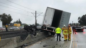 Authorities work to clear the wreckage after a big rig crashed and burst into flames on the Gold Line tracks along the 210 Freeway near Madre Street in Pasadena on Oct. 13.