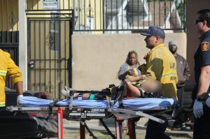 A blurred photo shows a child being taken from the scene of a crash in Vermont-Slauson on Oct. 23, 2018. (Credit: Pinkey Gray)