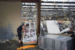 A man takes some tobacco products from a damaged store after Hurricane Michael passed through the area on Oct. 10, 2018, in Panama City, Florida. (Credit: Joe Raedle / Getty Images)