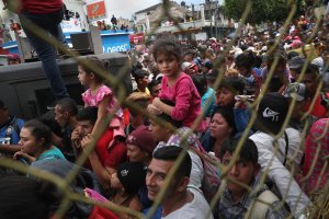 Members of a migrant caravan push forward at a gate separating Guatemala from Mexico on Oct. 19, 2018, in Ciudad Tecun Uman, Guatemala. (Credit: John Moore / Getty Images)